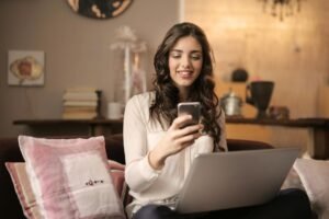 Profissional usando smartphone e laptop em casa